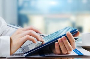 Person filling out insurance information on a tablet